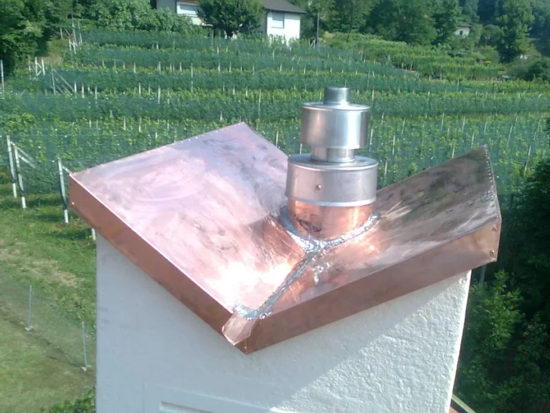 Copertura di un camino in rame, sullo sfondo i vigneti